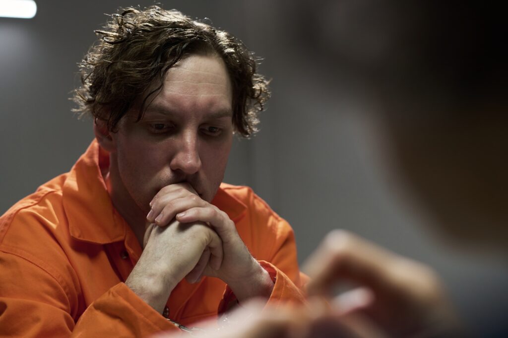 Contemplating Person in Orange Prison Uniform